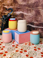 Colorful steel tumblers on a floral-patterned surface with a marble background