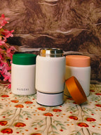 Three insulated containers with different colored lids on a floral-patterned surface.