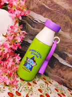 Green water bottle with purple lid and 'Happy Little World' design on a floral and patterned surface.