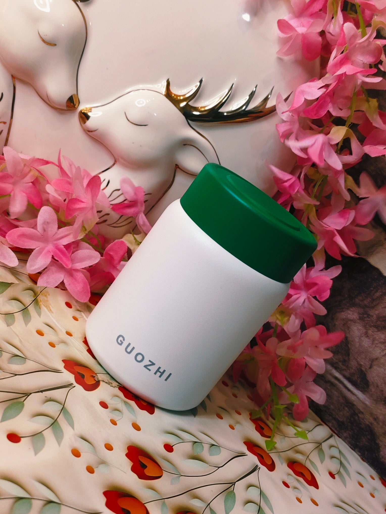 White food jar with green cap labeled 'GUOZHI'in stainless steel