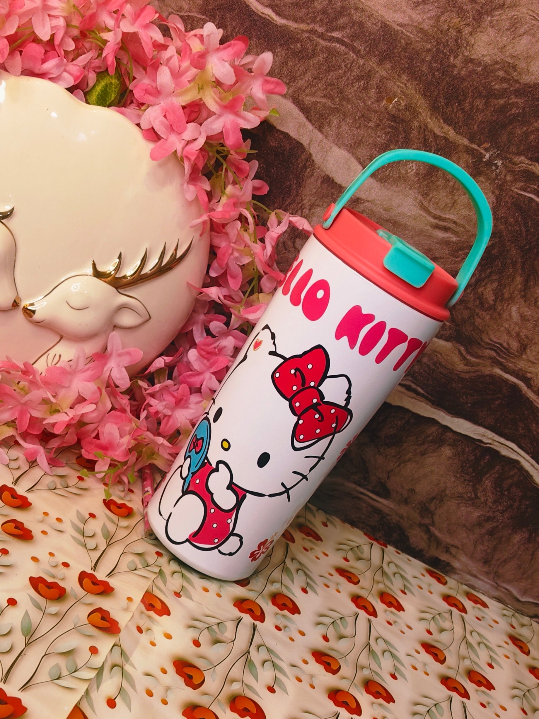 Hello Kitty tumbler with a bow design on a floral surface