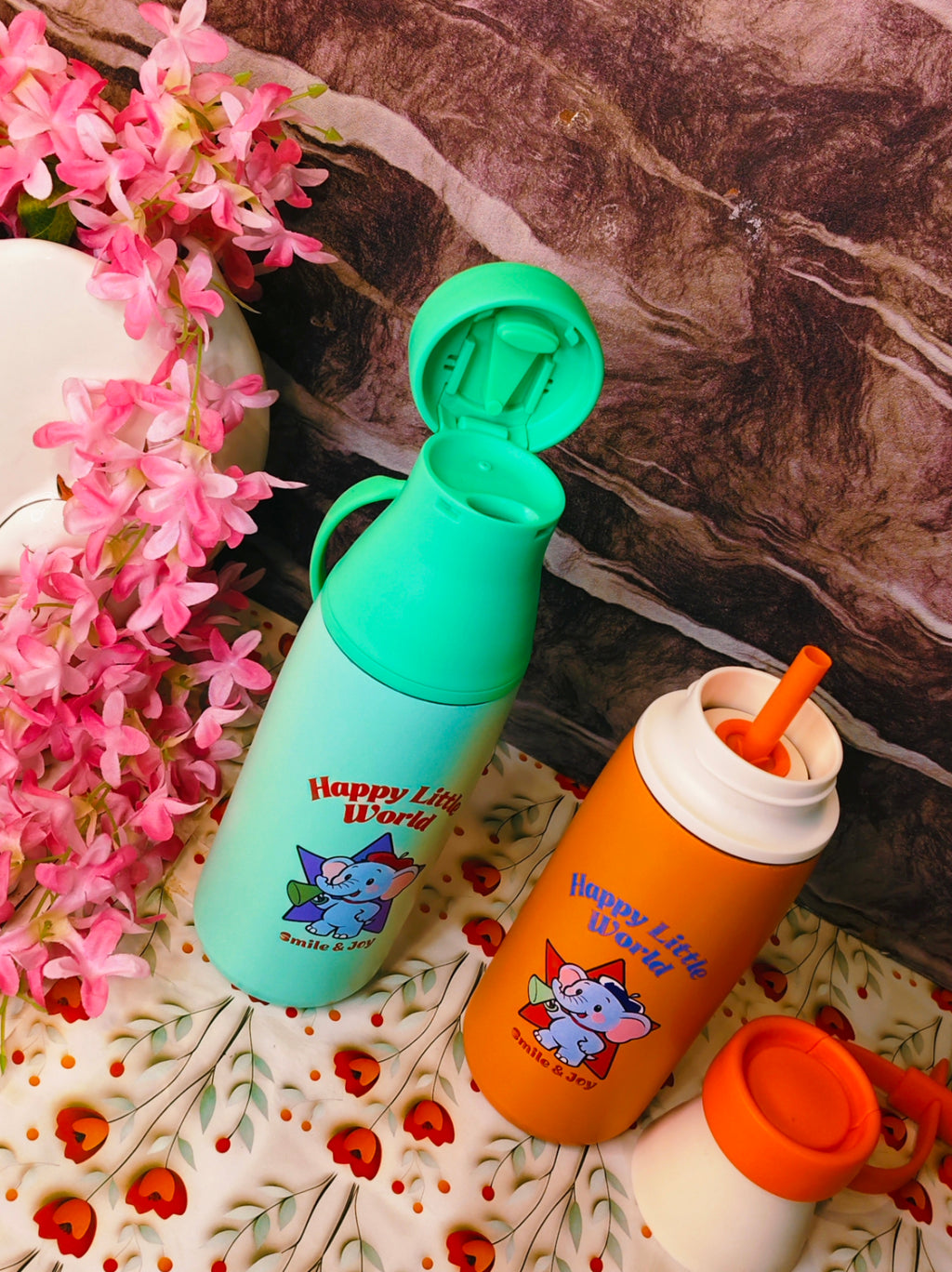 Two children's water bottles with cartoon characters on a floral surface.