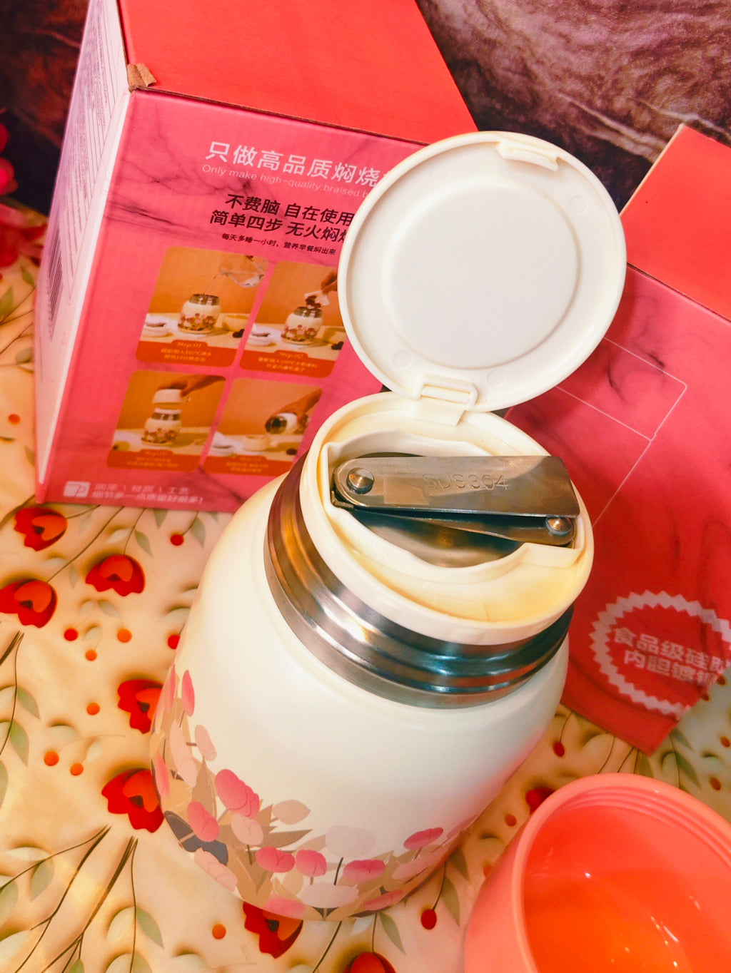 Vacuum flask with a lid on a floral surface